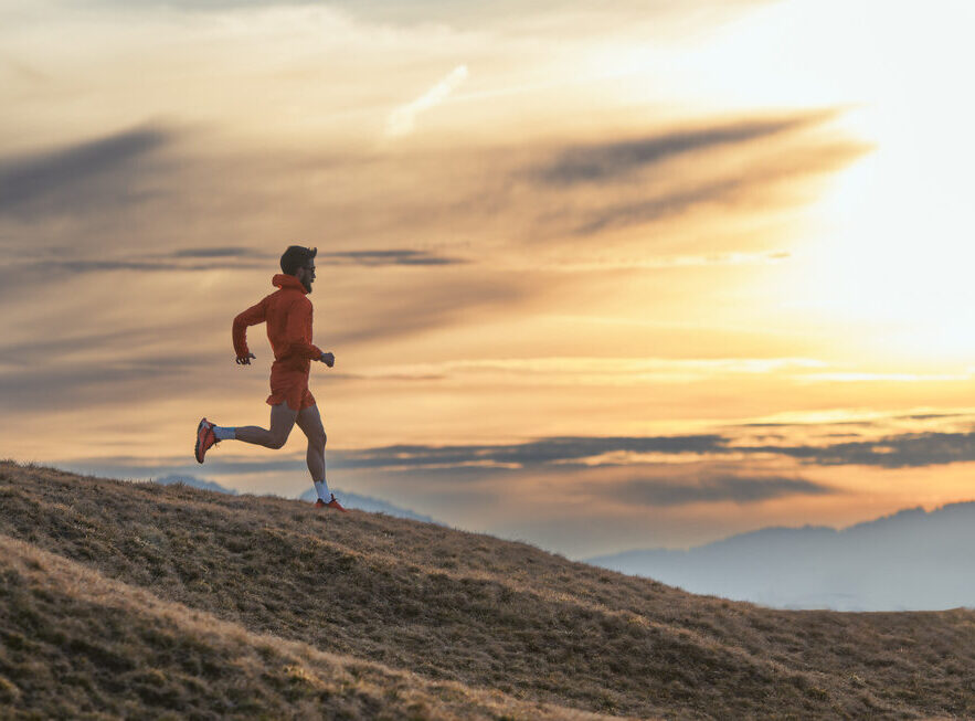 Athlete runs downhill in training on grass